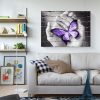 Purple Butterfly On Hand On Gray Wall